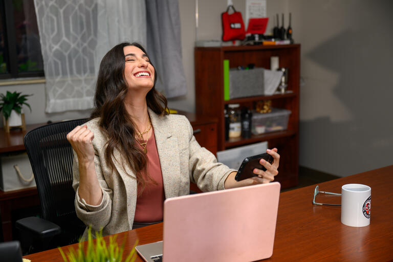 Mom watching child's game on SportsEngine Play in her office